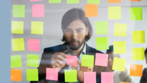 5 Reasons Why You Should Become a Scrum Master - a man looking at a Kanban board